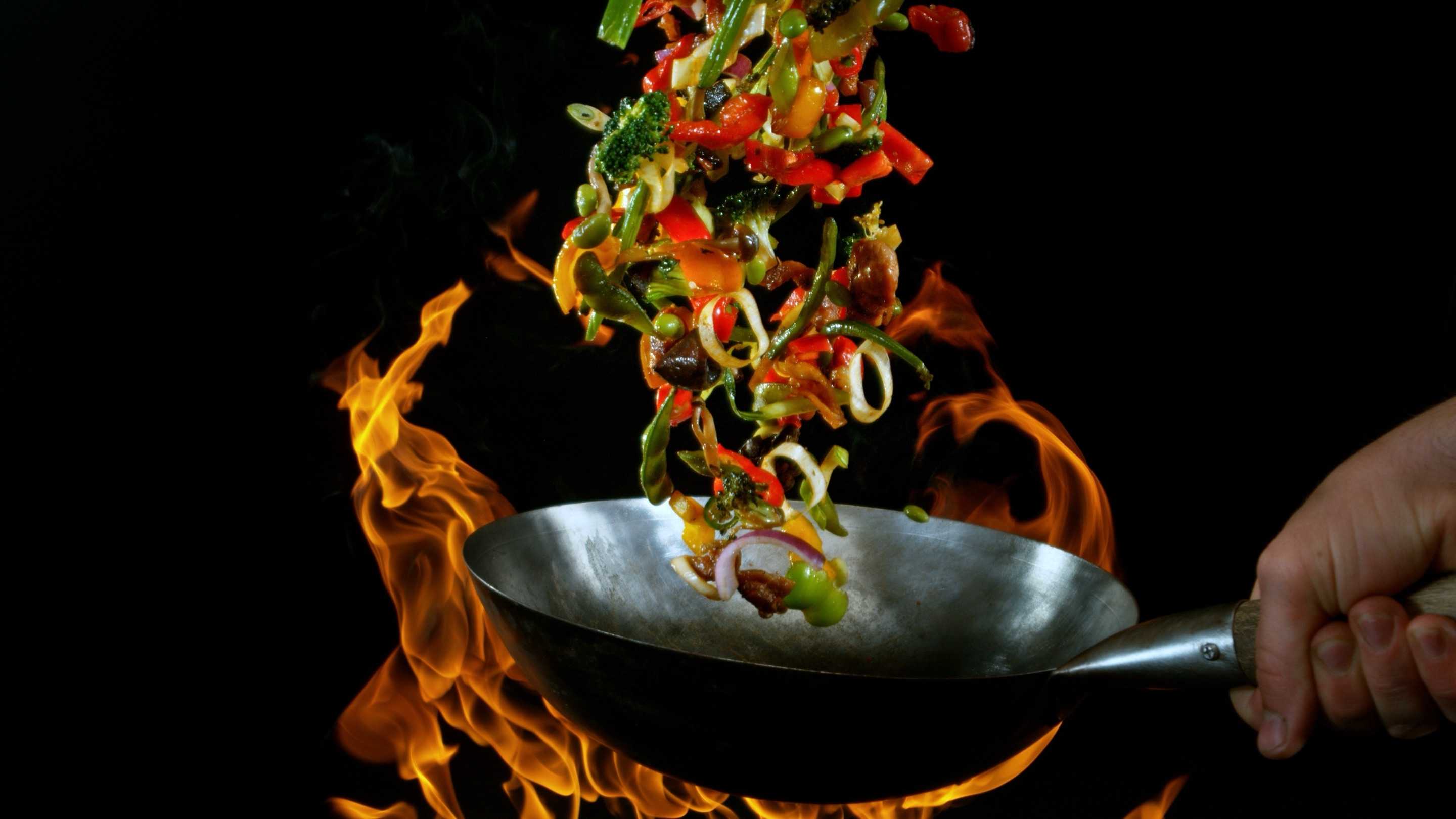 Vegetales salteados en un wok al fuego de China Wok